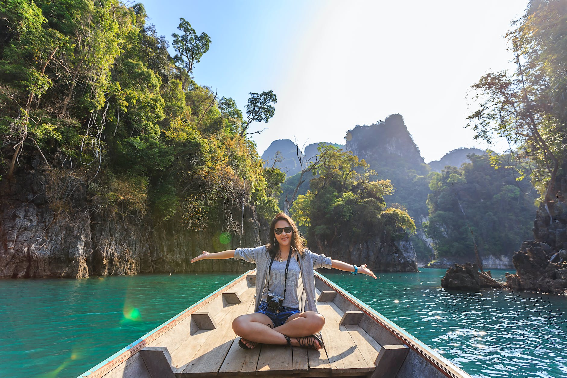 photo of woman sitting on boat spreading her arms. LUSH associatin. Hotels